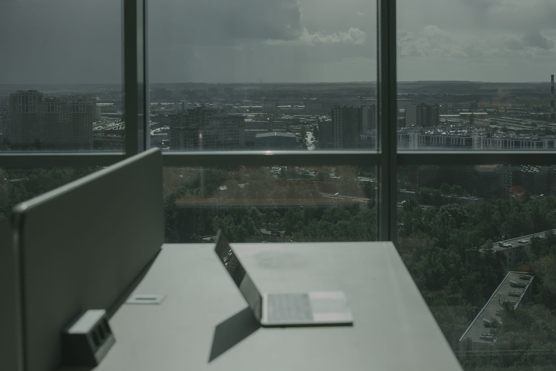 A desk by the window with the city beyond