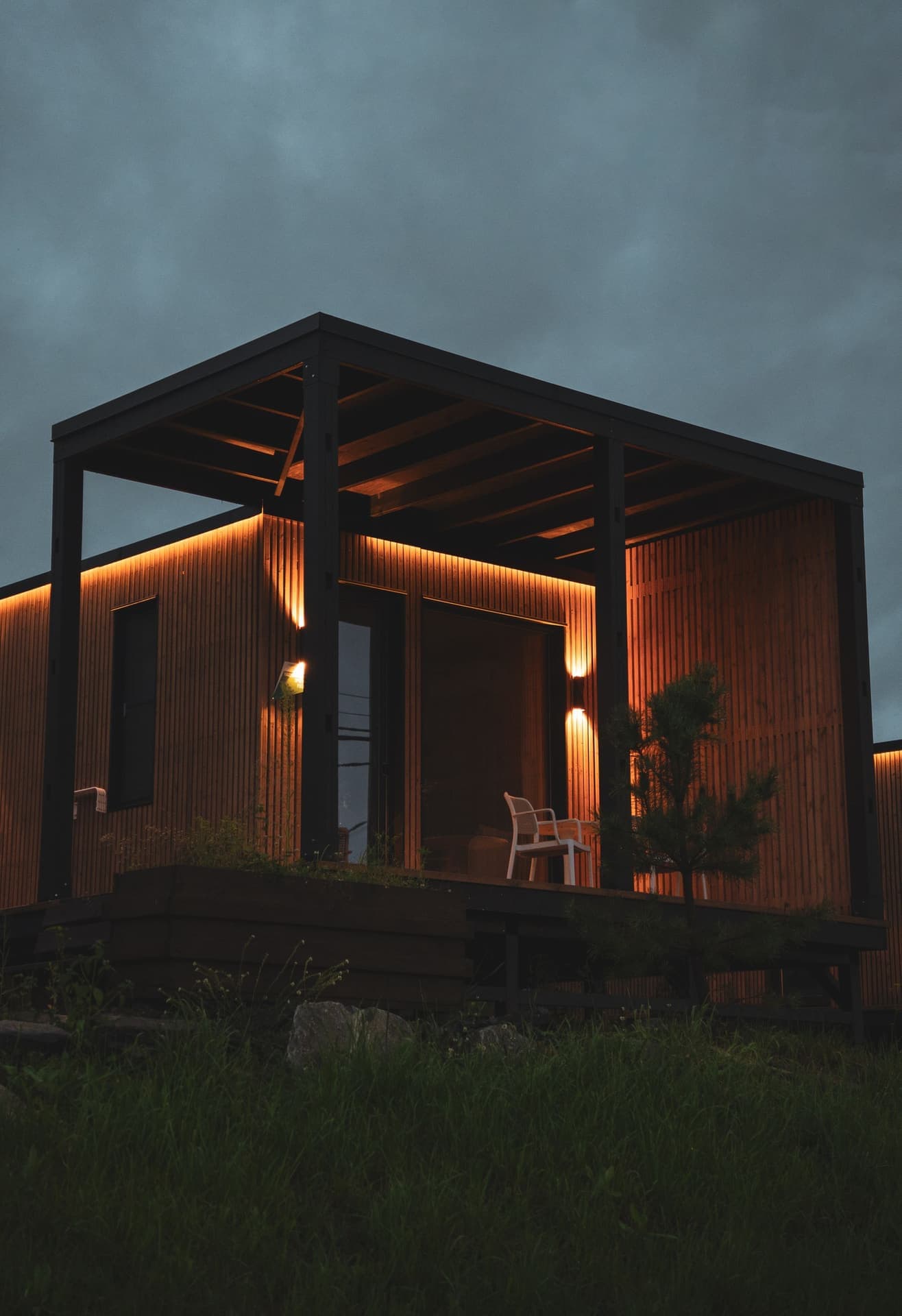 A timber home lit in the evening